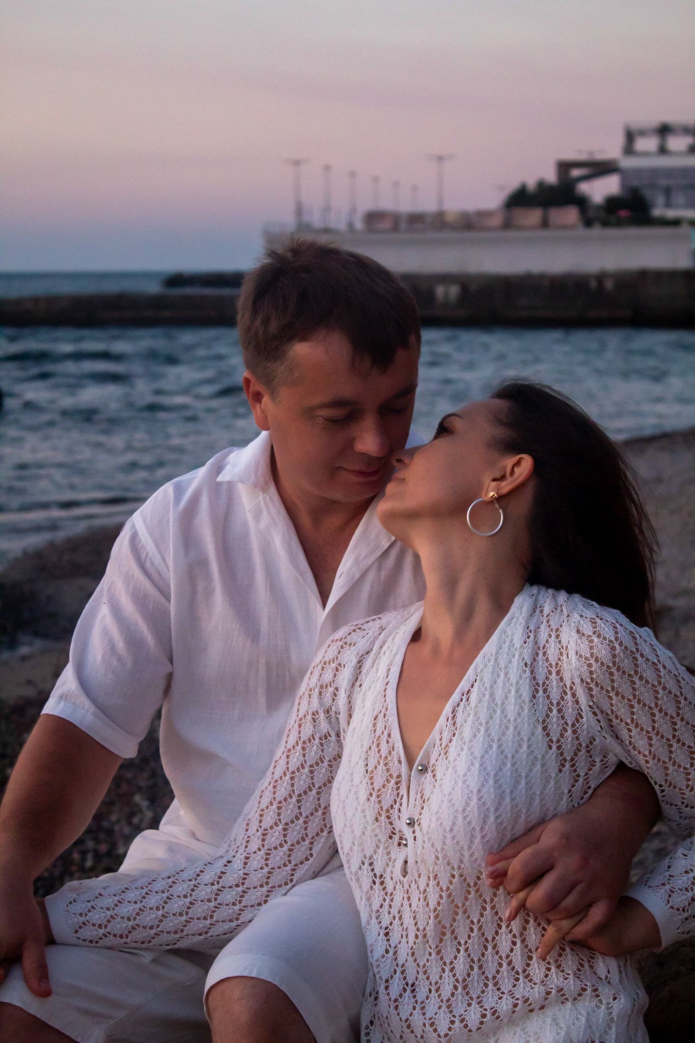 Чоловік цілує жінку в щоку на березі моря